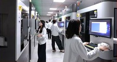 Team member working at a computer station between CNC machine lines