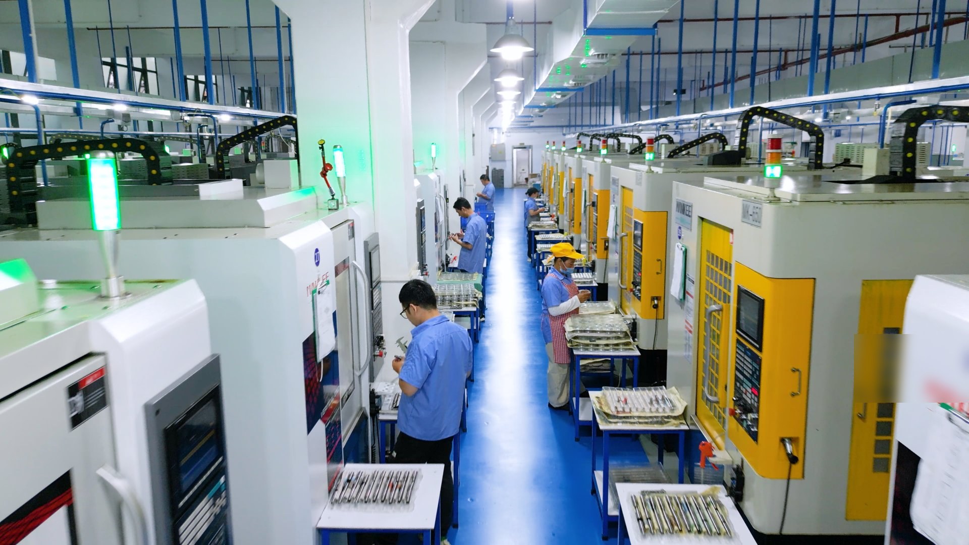 Skilled workers operating CNC machines on the production floor