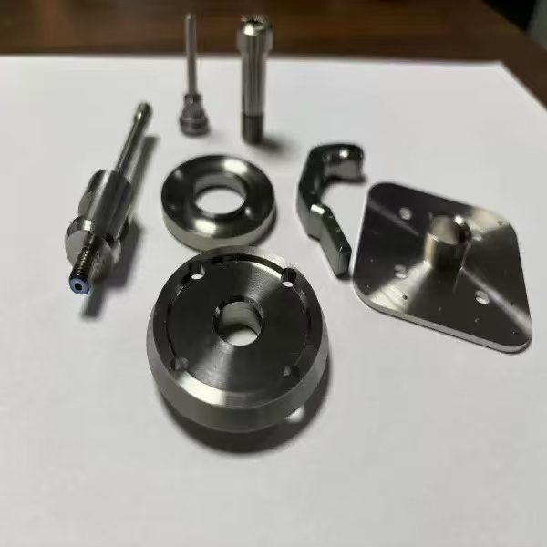 Stainless steel CNC precision parts laid out on a bench — enclosures and fittings