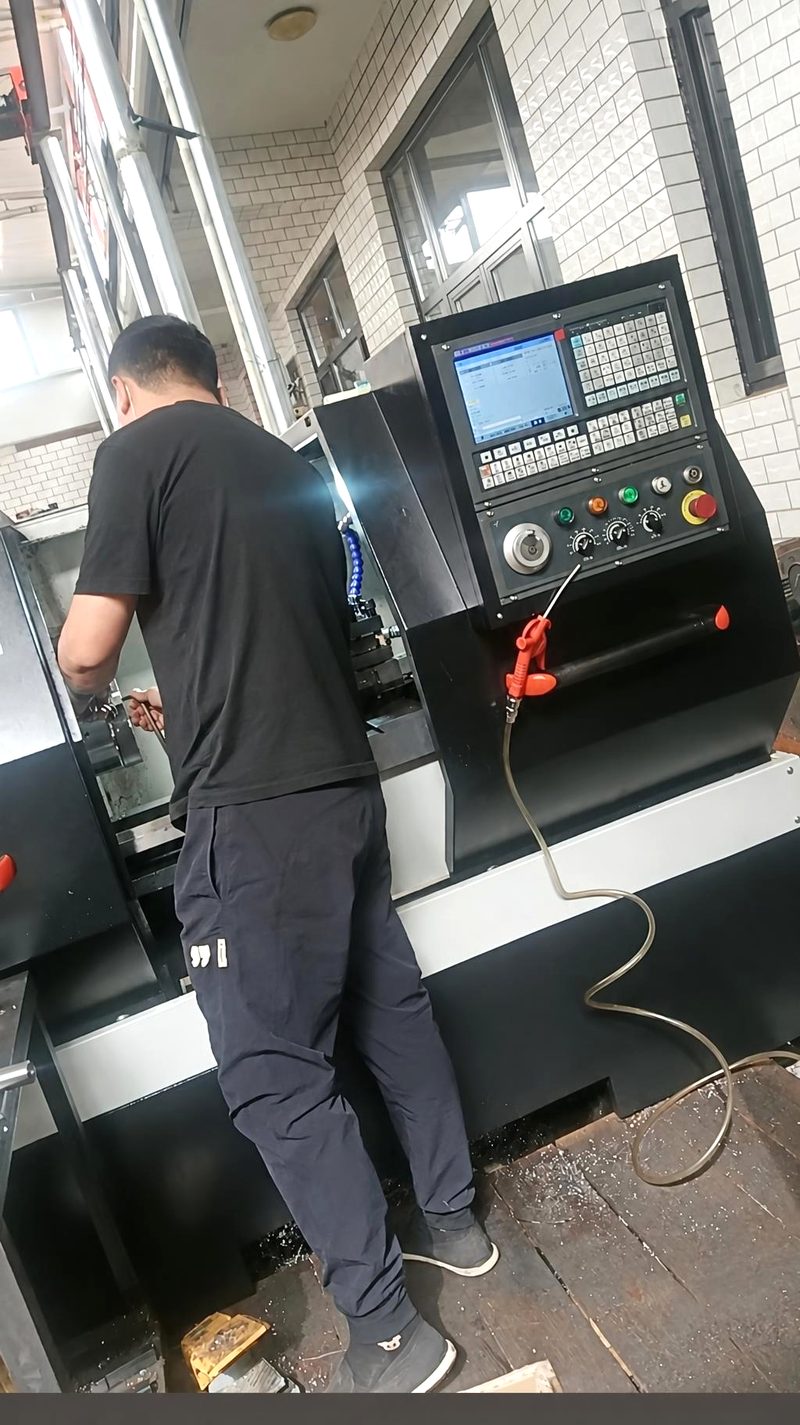 Operator setting up a job on a CNC lathe in our workshop